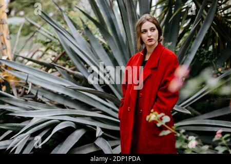 Donna con cappotto rosso in un parco Foto Stock