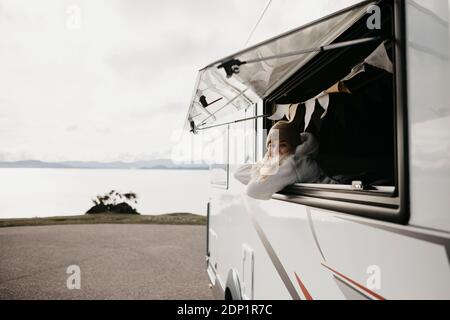 Regno Unito, Scozia, Highland, giovane donna alla finestra di un camper Foto Stock