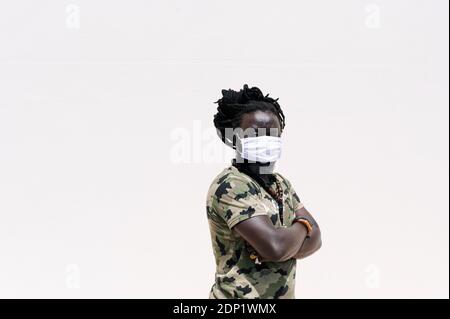 Uomo con dreadlock che indossa una maschera protettiva Foto Stock