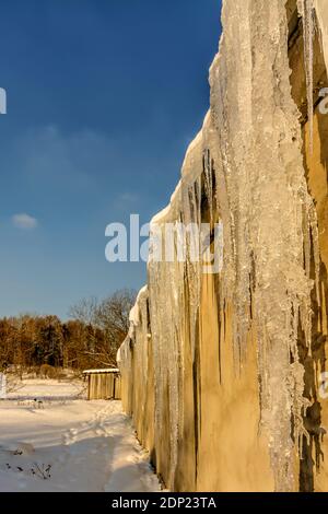 Grandi icicles formati sul tetto durante lo scongelamento. Foto Stock