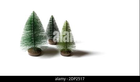 Piccoli alberi artificiali di Natale isolati su uno sfondo bianco. Concetto invernale minimo. Banner. Spazio di copia. Foto Stock