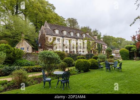 Il Cotswold Stone Swan Hotel a Bibury, un piccolo villaggio incontaminato Gloucestershire, nel Cotswolds, visto dal suo giardino Foto Stock