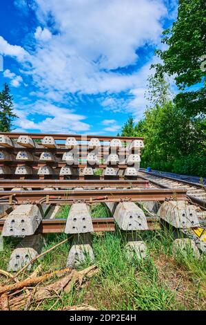 Berlino, Germania - 29 maggio 2020: Pila di traversine e rotaie in calcestruzzo in cantiere su una linea ferroviaria a Berlino Sud. Foto Stock