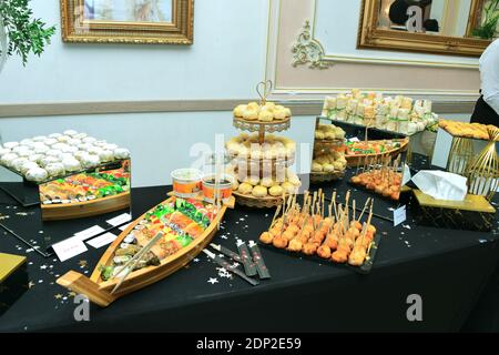 Un buffet di vari macaron salati, sushi e dolci orientali Foto Stock