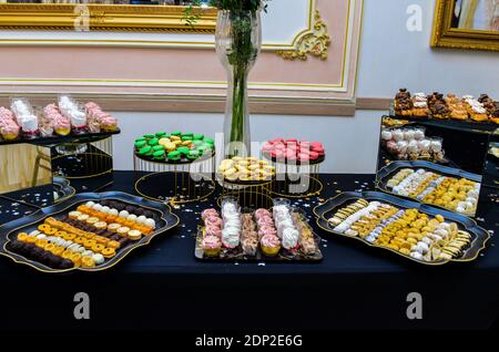 Un buffet di vari macaron salati, sushi e dolci orientali Foto Stock