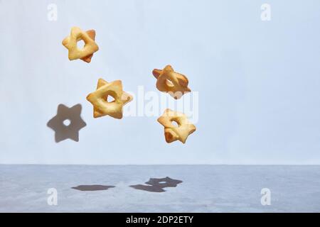 Biscotti levitanti a forma di stella ebrea esagonale di Davide. Esagramma. Spazio di copia Foto Stock