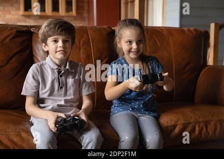 Emozionato fratellino e sorella che gioca console video gioco Foto Stock