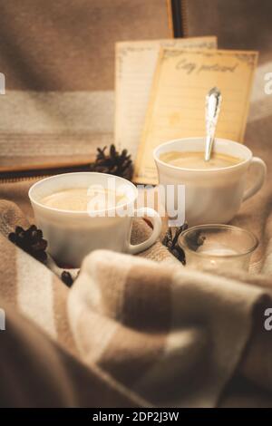 Accogliente tonalità in tonalità calde con due tazze di caffè caldo sul piatto, scenario e foto decorazione invernale Foto Stock