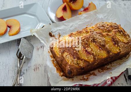 Deliziosa torta con pesche sul tavolo Foto Stock