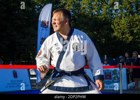 RIGA, LETTONIA. 31 agosto 2019. Tang Soo fare arti marziali master performance. Rompere i mattoni. Foto Stock