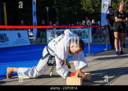 RIGA, LETTONIA. 31 agosto 2019. Tang Soo fare arti marziali master performance. Rompere i mattoni. Foto Stock