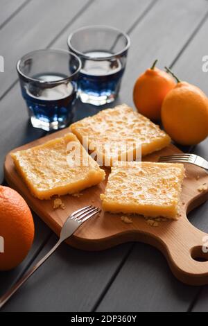 Disintossicare bevande e dolci sani. anchan biologico o tè blu farfalla pisello con torta al limone e frutta fresca su sfondo scuro verticale Foto Stock