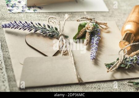 cartoncini per la scrittura di nomi vuoti, busta sul tavolo con fiore di lavanda Foto Stock