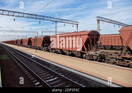 carrier carrier carrier carrier carrier carrier per il trasporto di merci sfuse di colture di grano, binario ferroviario con rotaie e vagoni che entrano in prospettiva, sfondo su t Foto Stock