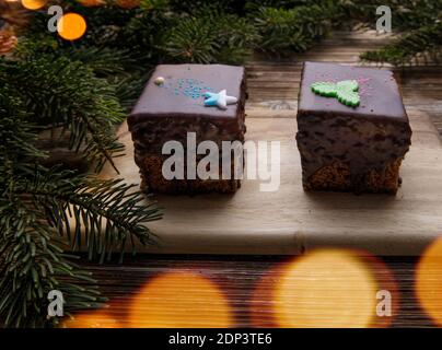 due biscotti di pan di zenzero in glassa di cioccolato su una tavola di legno. Foto Stock