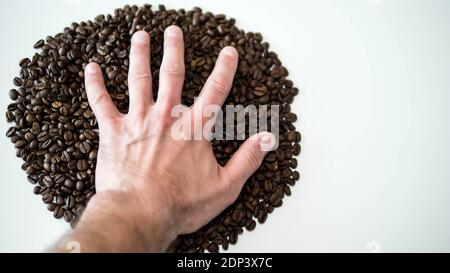 Chicchi di caffè tostati profumati. Chicchi di caffè, logo, carta da parati da chicchi di caffè, immagine creativa da germogli di fagioli, primo piano. Foto Stock