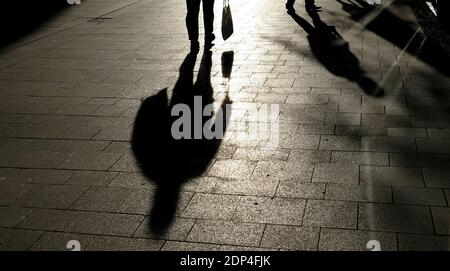 Amburgo, Germania. 18 Dicembre 2020. Un uomo che porta una borsa cammina attraverso un centro commerciale pedonale durante il blocco, silhouette e ombreggiato. Credit: Daniel Bockwoldt/dpa/Alamy Live News Foto Stock