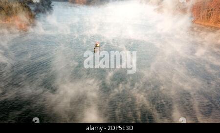 Pechino, Cina. 16 Dic 2020. Foto aerea scattata il 16 dicembre 2020 mostra il medico del villaggio Yu Jiajun che fa una visita in barca ai pazienti su un isolotto di riserva isolato nella contea di Jinzhai di Lu'an, provincia di Anhui della Cina orientale. Credit: Zhang Duan/Xinhua/Alamy Live News Foto Stock