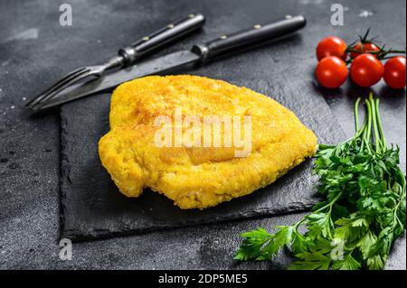 Weiner Schnitzel tedesco con breaded fatto in casa. Sfondo nero. Vista dall'alto. Foto Stock