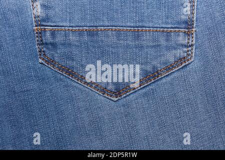 Parte inferiore appuntita di una tasca di jeans denim blu. Primo piano. Vista dall'alto. Negozio di abbigliamento e concetti di shopping. Spazio di copia. Foto Stock
