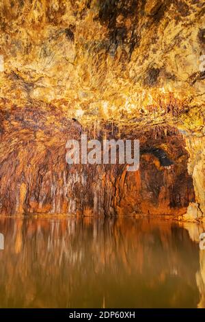 Riflessi rossi di ferro in acqua nel colorato Grotte delle fate a Saalfeld Foto Stock