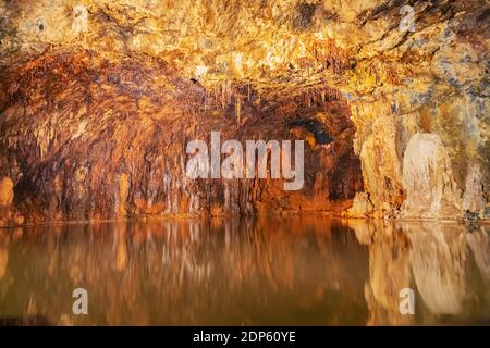 Ferro ed altri minerali che riflettono in acqua satinata in Le colorate Grotte delle fate di Saalfeld Foto Stock