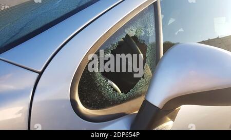 Il burglar ha rotto il finestrino laterale della macchina per rubare. Un esempio di assicurazione contro le rapine. Foto Stock