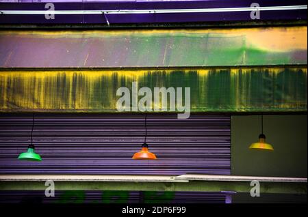 Blocco. Lampade colorate appese all'esterno del bar chiuso. Scena urbana. Sfondo astratto e sfrenato stile di vita. Crisi economica, rinnovamento, decadimento. Foto Stock