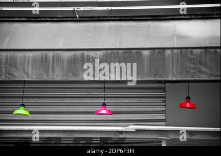 Blocco. Lampade colorate appese all'esterno del bar chiuso. Scena urbana. Sfondo astratto e sfrenato stile di vita. Crisi economica, rinnovamento, decadimento. Foto Stock