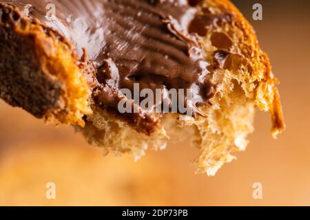 A colazione si mangia una fetta di pane fatto in casa con crema al cioccolato. Messa a fuoco selettiva. Profondità di campo poco profonda. Foto Stock