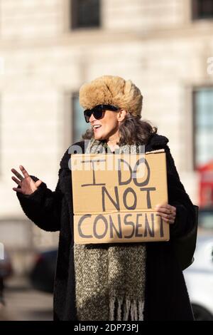 Donna in pelliccia cappello con un cartello 'non acconsento' durante la protesta contro il vaccino COVID-19, Parliament Square, Londra, 14 dicembre 2020 Foto Stock