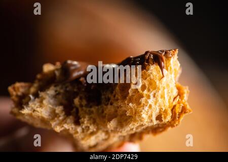 A colazione si mangia una fetta di pane fatto in casa con crema al cioccolato. Messa a fuoco selettiva. Profondità di campo poco profonda. Foto Stock