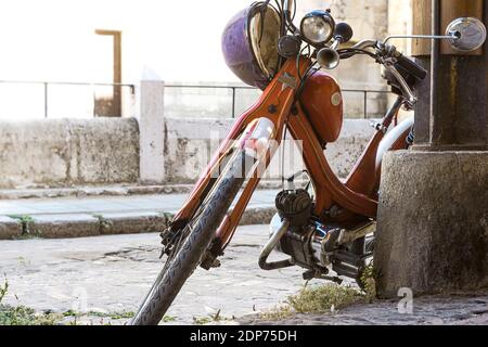 moto vecchio e molto vecchio che pende su una colonna dentro La città di Leon in Spagna Foto Stock