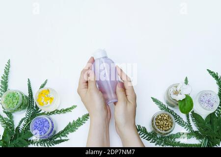Cosmetici micellari per acqua detergente nelle mani femminili. Copia spazio per testo, spa, benessere o omeopatia Foto Stock
