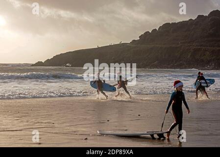 Langland Bay, Swansea, Regno Unito. 19 dicembre 2020. I surfisti vestiti con abiti di Natale del Padre si portano al mare a Langland Bay vicino a Swansea questa mattina nel tempo tempestoso. PIC di Lisa Dawson Rees Credit: Phil Rees/Alamy Live News Foto Stock