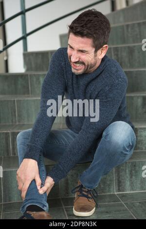 uomo d'affari anziano che soffre di lesioni all'interno della lobby dell'ufficio Foto Stock