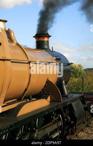 Vecchia locomotiva vintage treno a vapore con fumo che soffia dal suo imbuto camino, foto stock Foto Stock