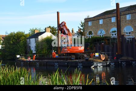 Riparazioni sulla riva del fiume Great Ouse a St Neots Cambridgeshire attrezzatura su pontile galleggiante utilizzato per guidare in acciai. Foto Stock