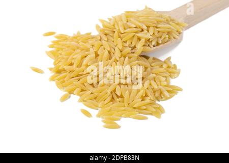 In Grecia chiamato kritharaki. In Italia si chiama Orzo. Pasta a forma di riso in cucchiaio di legno isolato su sfondo bianco. Tipo di pasta. Ingrediente alimentare. Foto Stock