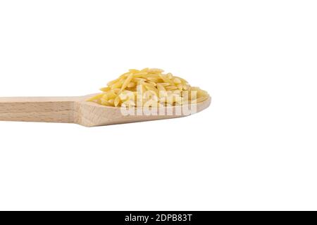 In Grecia chiamato kritharaki. In Italia si chiama Orzo. Pasta a forma di riso in cucchiaio di legno isolato su sfondo bianco. Tipo di pasta. Ingrediente alimentare. Foto Stock