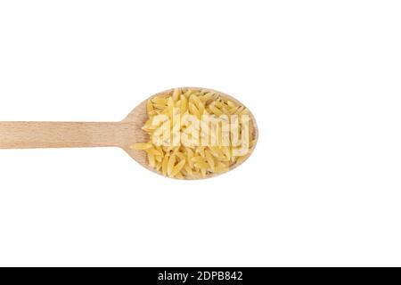 In Grecia chiamato kritharaki. In Italia si chiama Orzo. Pasta a forma di riso in cucchiaio di legno isolato su sfondo bianco. Tipo di pasta. Ingrediente alimentare. Foto Stock