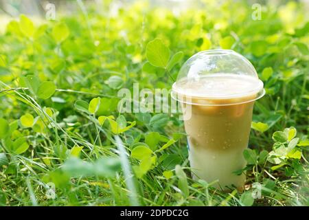 Latte ghiacciato in tazza di plastica, bevanda da asporto in erba verde Foto Stock