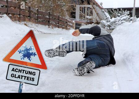 Pericolo di incidenti in inverno. Un uomo scivola fuori sulla strada liscia Foto Stock