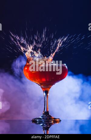 Bicchiere di gustoso caffè martini con spruzzi su sfondo scuro Foto Stock