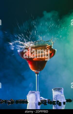 Bicchiere di gustoso caffè martini con spruzzi su sfondo scuro Foto Stock