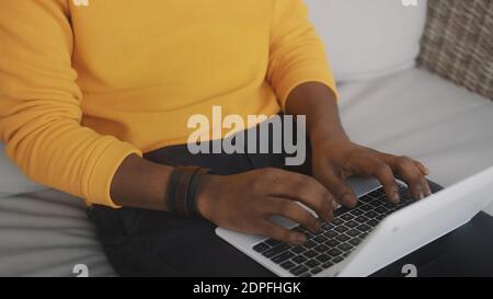 Primo piano, uomo nero che usa il notebook in interni. Foto di alta qualità Foto Stock