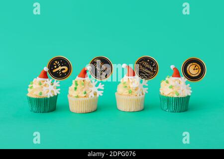 Gustosi cupcake natalizi su sfondo colorato Foto Stock