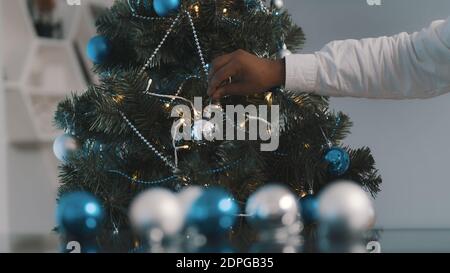 Primo piano, albero di natale docoration. Uomo nero afroamericano che decora l'albero di natale. Foto di alta qualità Foto Stock