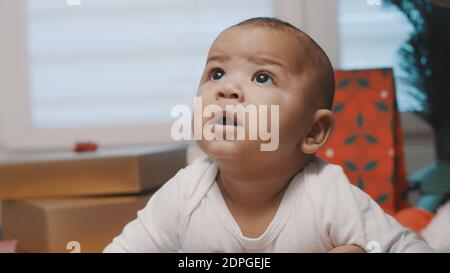 adorabile bambino di fronte all'albero di natale. Presenta in background. Foto di alta qualità Foto Stock