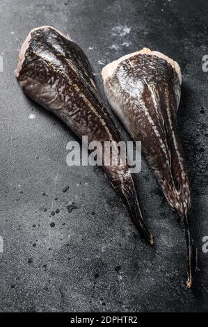 Pesce monaco fresco senza testa. Sfondo nero. Vista dall'alto. Foto Stock